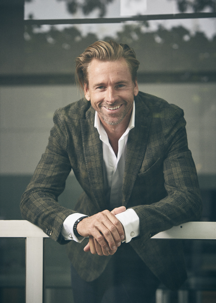Niklas smiling, leaning forward on a white railing